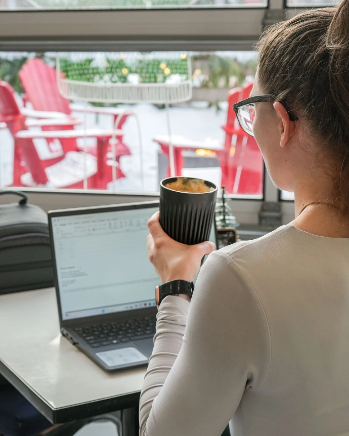 Image de femme qui boit du café en travaillant au bureau